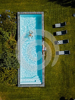 Drone view at swimming pool above with man and woman swimming Stellenbosch, near Cape Town, South Africa