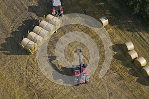Drone view of tractor collecting straw bales