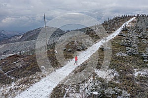 Drone view on a trail running woman in a beautiful winter landscape.