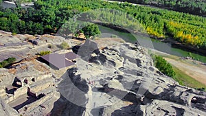 Drone view of the Uplistsikhe cave complex and the Mtkvari River in Georgia on a sunny day