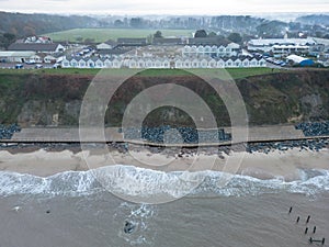 Drone view of waves hitting a sea defence system on the UK coast line