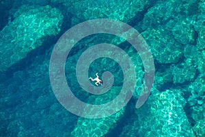 Drone view of a woman snorkeling in the sea