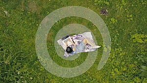 Drone view young woman working on laptop on green grass