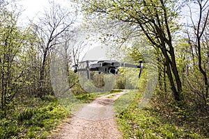 Drone in the woods, a drone flys in the  woods over the foot path