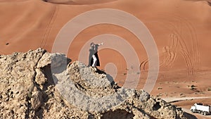 Drones will fly around a man dressed as a shaman, standing on a rock in the middle of the desert sands and playing the