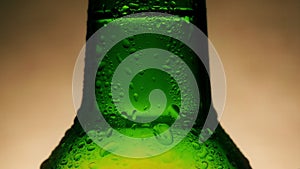 Drop of condensate drains on a green bottle of beer