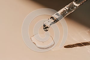 A drop of cosmetic oil falls from the pipette