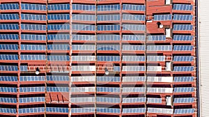 Drop down view of solar power plant with panels placed on industrial roof tops.