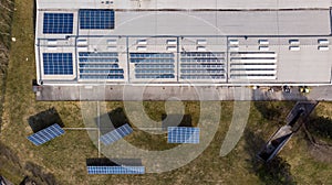 Drop down view of solar power plant with panels placed on industrial roof tops.