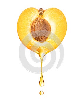 A drop dripping from a half of apricot close up on a white background