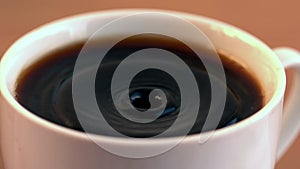Drop falling into cup of coffee