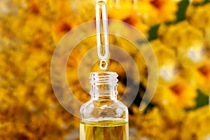 Drop falling from dropper of essential oil, aromatherapy essence, or medicinal liquid