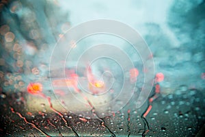 Drop on glass at twilight time while raining.View side out the car.Rain drops on window with road light bokeh,