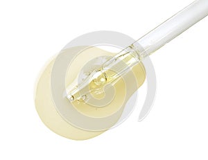 Drop of hydrophilic oil from pipette on white background