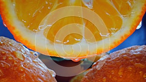 a drop of juice falls from a cut orange slice. shot in close-up