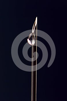 Drop of medicine on the tip of a medical injection needle