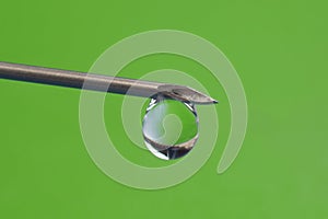 Drop of medicine on the tip of a medical injection needle