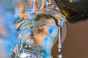 Drop of melting ice water from drainpipe