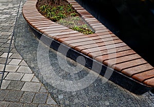 drop shaped or ellipse bench on cobbled square. the paneling of