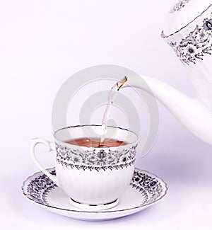 Drop tea from teapot to teacup photo