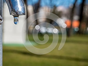 Drop of water close up with a blurred green background