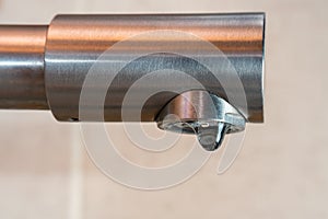 A drop of water drips from a leaky faucet
