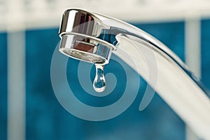 A drop of water drips from a leaky faucet