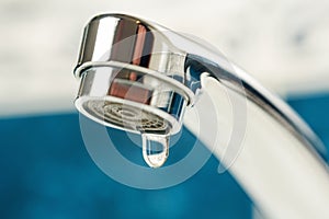 A drop of water drips from a leaky faucet