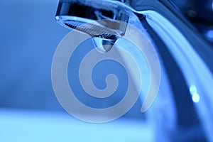 Drop of water falling from a faucet photo