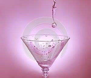 Drop of water falling in martini glass