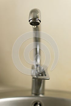 A drop of water flows down from the kitchen water tap