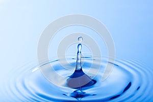 Drop of water. Water droplet falling impact with water surface. causing rings on water surface