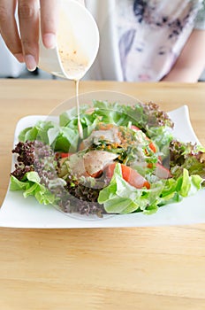 Droping salad cream to salad of shrimp, crab meat, lettuce