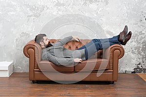 Dropped into sleep. Bearded man take nap on sofa. Hipster sleep wearing clothes and shoes. Nap or daydream. Work break