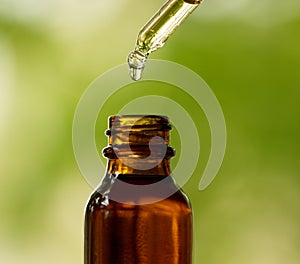 Dropper With Amber Bottle and Green Background photo