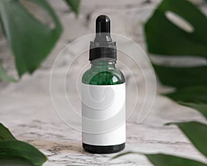 Dropper Bottle on monstera leaf on marble table close up. Brand packaging mockup