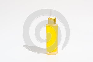 Dropper bottle of yellow serum or essential oil isolated on white background. Organic skin care cosmetics with Vitamin C