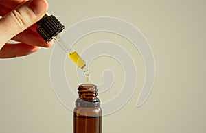 Dropper of cbd or thd oil in human hands.