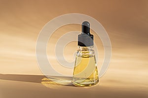 Dropper of essential oil, aromatherapy essence, or medicinal liquid on beige background. Natural cosmetics concept