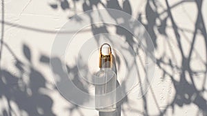 Dropper glass Bottle Mock-Up. osmetic pipette on white background with shadows of leaves