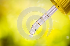 Dropper on a natural background. Green background. Medicine, aromatherapy. Dropping pipet.