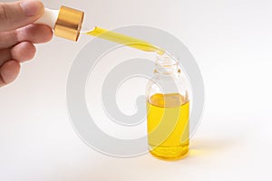 Dropper with oil serum glass bottle and female hand photo