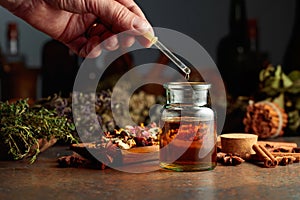 Dropping essential herbal tincture into a small glass bottle