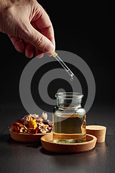 Dropping essential oil or herbal tincture into a small bottle