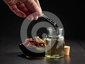 Dropping essential oil or herbal tincture into a small bottle