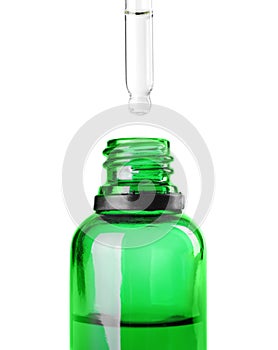 Dropping herbal essential oil into bottle isolated