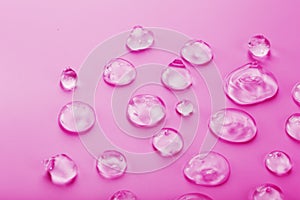 Drops of antiviral gel on a pink background with free space.