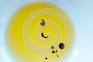 Drops of balsamic vinegar in a bowl of olive oil