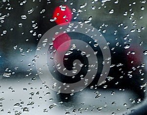 Drops on car glass against the background of blurry night street lights