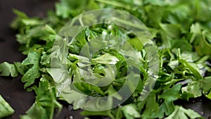 Drops of clean water falling on the green leaves of fresh chopped organic parsley